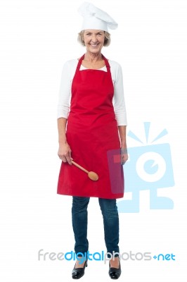 Cheerful Senior Female Chef With Spoon Stock Photo