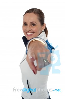 Cheerful Woman Standing Sideways And Pointing At You Stock Photo