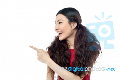 Cheerful Young Girl Pointing Away Stock Photo