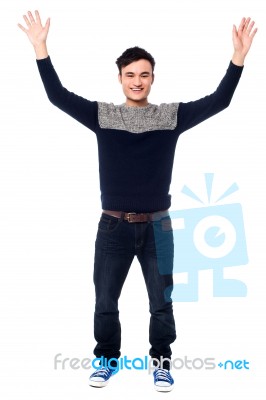 Cheerful Young Guy Raising His Arms Stock Photo