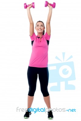 Cheerful Young Woman Lifting Dumbbells Stock Photo