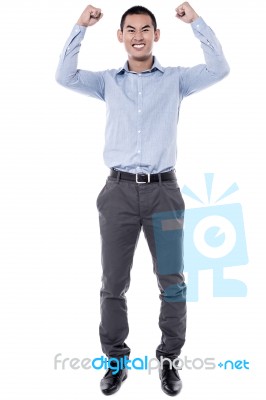 Cheering Young Man Against A White Background Stock Photo