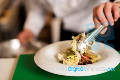 Chef Arranging Tossed Salad In A White Bowl Stock Photo