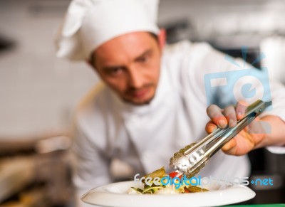 Chef Arranging Tossed Salad In A White Bowl Stock Photo