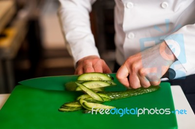 Chef Chopping Leek Over Green Carving Board Stock Photo