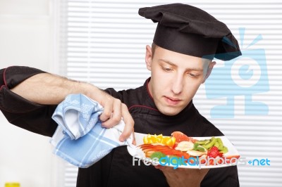 Chef Cleaning Edge Of Plate With Cloth Stock Photo