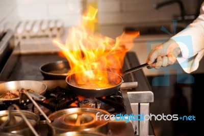 Chef Cooking In Kitchen Stove Stock Photo