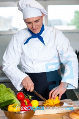 Chef Cutting Vegetables In Kitchen Stock Photo