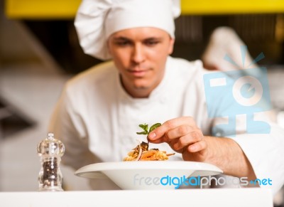 Chef Decorating Pasta Salad With Herbal Leaves Stock Photo