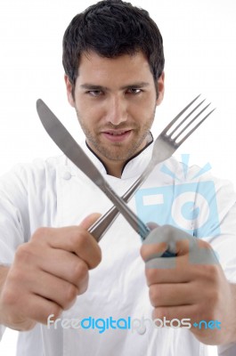 Chef Holding Crossed Fork And Knife Stock Photo