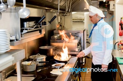 Chef With Burning Flames On Kitchen Stock Photo