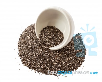 Chia Seeds Spilling Out From White Bowl Stock Photo