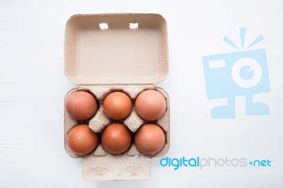 Chicken Eggs In Egg Box On White Wooden Background Stock Photo