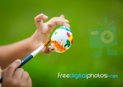 Child Hand Painting Easter Egg With Paintbrush Stock Photo