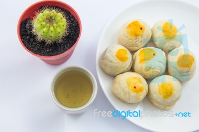 Chinese Pastry Mung Bean Or Mooncake With Egg Yolk On Dish And Green Tea Cup And Cactus Pot Stock Photo