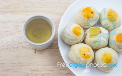 Chinese Pastry Mung Bean Or Mooncake With Egg Yolk On Dish Wooden Table And Green Tea Cup Stock Photo