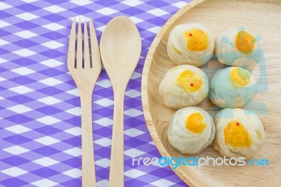 Chinese Pastry Mung Bean Or Mooncake With Egg Yolk On Wooden Dish And Spoon Fork Striped Cloth.chinese Pastry Mung Bean Or Mooncake With Egg Yolk On Wooden Dish And Spoon Fork Striped Cloth Stock Photo