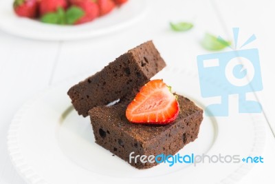 Chocolate Brownie Cake On White Plate Decorated With Strawberrie… Stock Photo