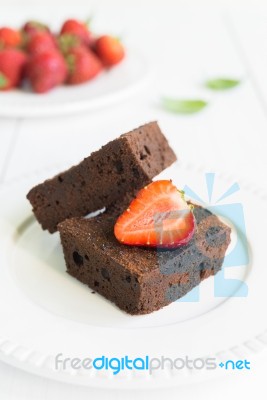 Chocolate Brownie Cake On White Plate Decorated With Strawberrie… Stock Photo