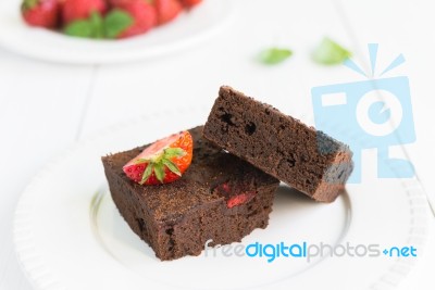 Chocolate Brownie Cake On White Plate Decorated With Strawberrie… Stock Photo