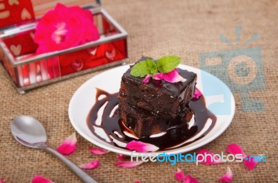 Chocolate Brownie On Plate With Rose Petals Stock Photo