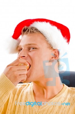 Christmas Hat Wearing Male Eating Apple Stock Photo