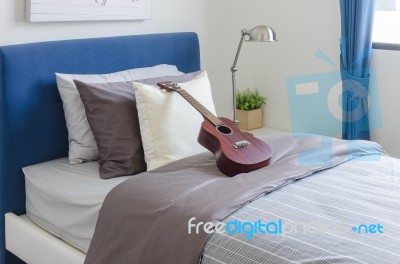 Classic Guitar On Kid's Bedroom With Pillows And Modern Lamp Stock Photo