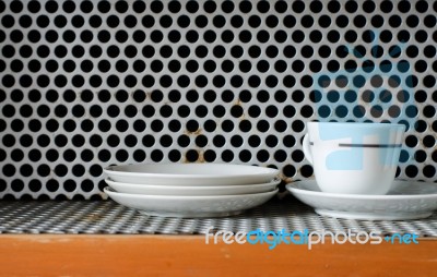 Clean Plates And Cups On Grunge Metal Grill Pattern Stock Photo