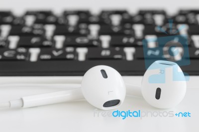 Close Up Earbuds Music Accessories On Laptop Computer Stock Photo