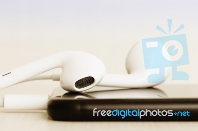 Close-up Headphone Stack On Phone Stock Photo