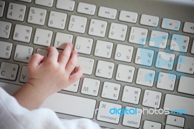 Close-up Of A Baby's Hand Using Keyboard Stock Photo