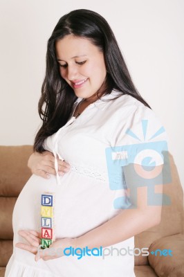 Close Up Of A Pregnant Woman With Baby Letters On Her Hand Stock Photo