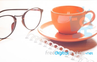 Close Up Of Coffee Cup With Book And Eyeglasses Stock Photo