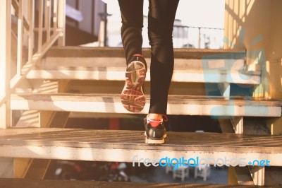 Close Up Of Feet With Sneakers Climbing Up The Stairs Stock Photo