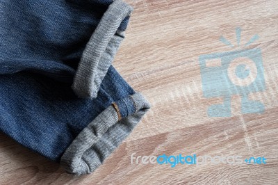 Close Up Of Fold Selvedge Denim Jeans On Wooden Background With Stock Photo