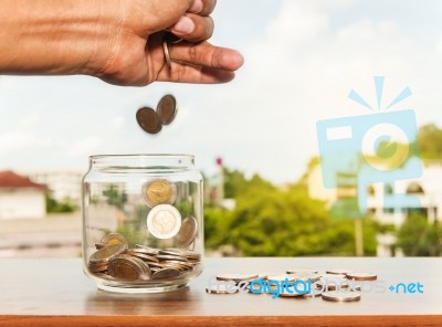 Close Up Of Glass Bottle Stacking Silver Coins Stock Photo