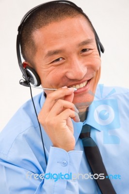 Close-up Of Smiling Male Customer Service Representative Wearing… Stock Photo