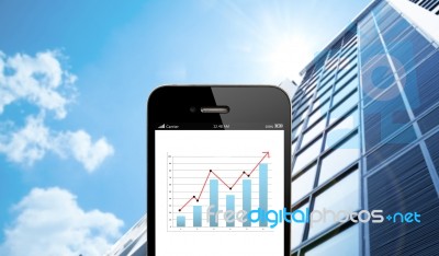 Close Up Smart Phone Against Business Building With Blue Sky Bac… Stock Photo