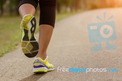 Close Up Sport Woman Running In Park During Sunset Stock Photo