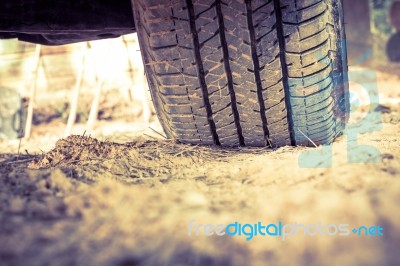 Closeup Car Tire On The Ground. Wheel Tracks On Dirt. Vintage Pi… Stock Photo