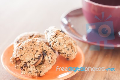 Closeup Cereal Cookies On Orange Plate And Coffee Cup Stock Photo