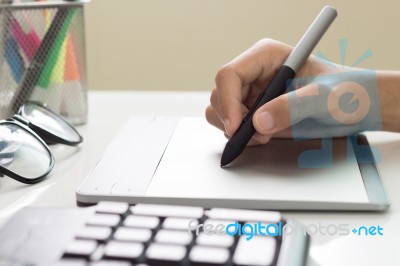 Closeup Designer Hand Using Graphic Tablet On Desk Stock Photo