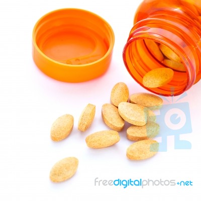 Closeup Of Orange Pills And Pill Bottle Stock Photo