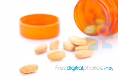 Closeup Of Orange Pills And Pill Bottle Stock Photo