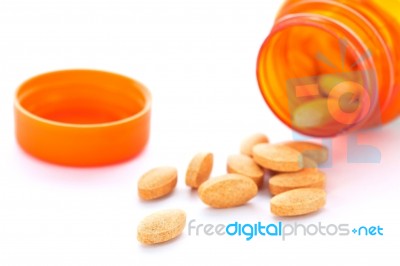 Closeup Of Orange Pills And Pill Bottle Stock Photo