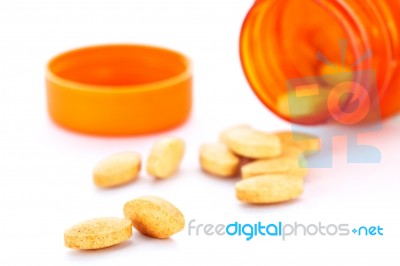 Closeup Of Orange Pills And Pill Bottle Stock Photo