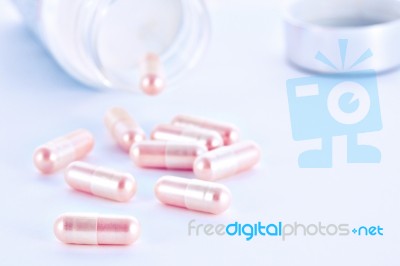 Closeup Of Pink Pills And Pill Bottle Stock Photo