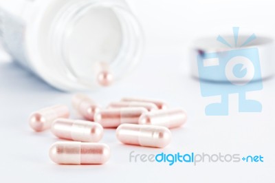 Closeup Of Pink Pills And Pill Bottle Stock Photo