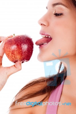 Closeup Of Young Girl Tasting The Apple By Her Tounge Stock Photo