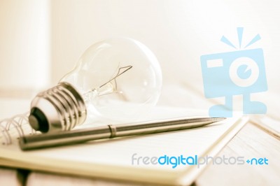 Closeup Pen On Notebook With Light Bulb, Creative Writing Concept Stock Photo